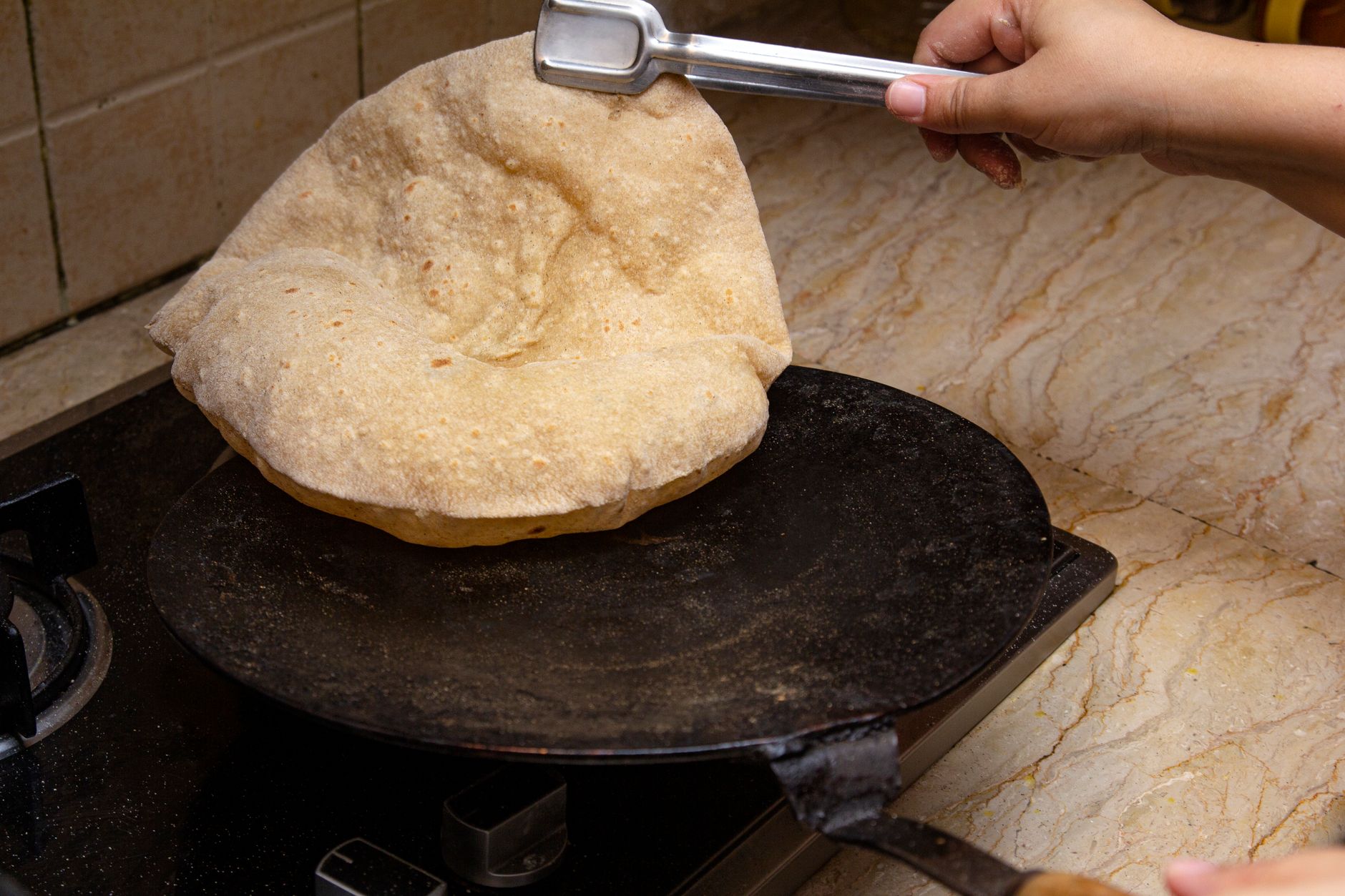 A homemade chapati cooking on the stove